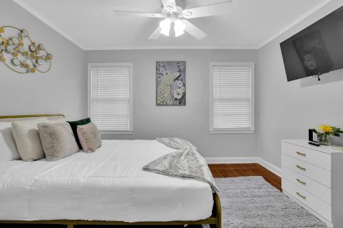 een witte slaapkamer met een bed en een plafondventilator bij GoodLiving: Serenity in Atlanta