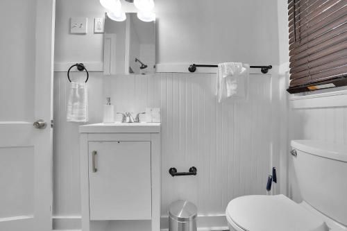 a white bathroom with a toilet and a sink at GoodLiving: Serenity in Atlanta