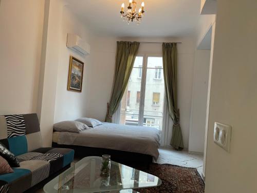 Habitación con cama, sofá y ventana en IMPERIA 2, en Niza
