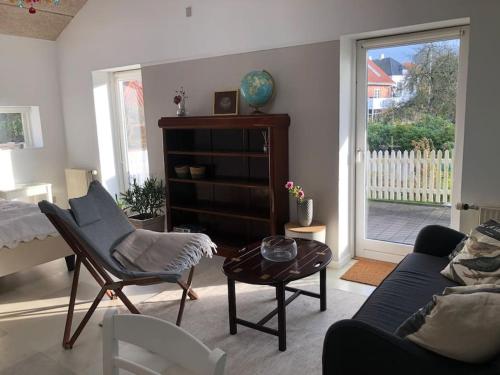 a living room with a couch and a table at Airy, cosy guesthouse in Mariager