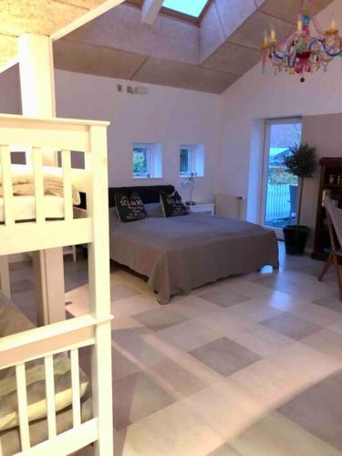 a large bedroom with a bed and a ladder at Airy, cosy guesthouse in Mariager
