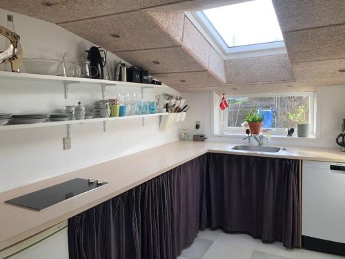 eine Küche mit einem Waschbecken und einem Fenster in der Unterkunft Airy, cosy guesthouse in Mariager