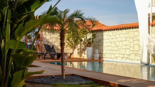 a man sitting in a chair next to a swimming pool at Aleysim Alaçatı-Design Als in Alaçatı