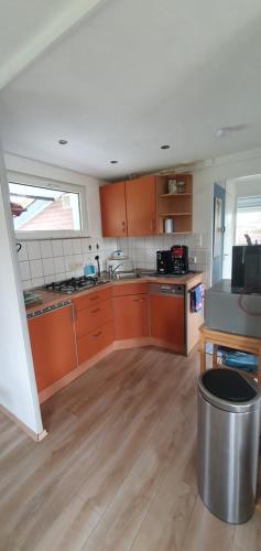 a kitchen with orange cabinets and a trash can at Hilton house in Lemmer