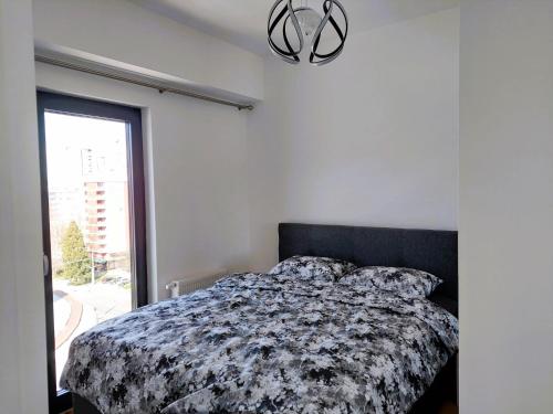 una camera da letto con un letto con un piumone bianco e nero di The Stadium View Apartment a Sarajevo