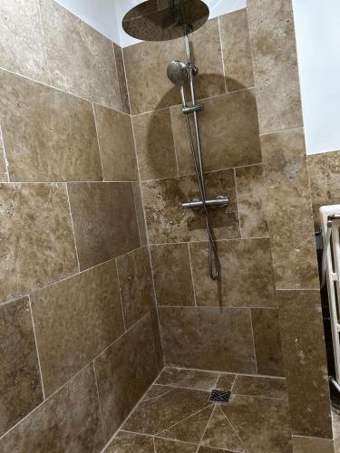 La salle de bains est pourvue d'une douche avec du carrelage brun. dans l'établissement la porte medievale, à Carcassonne