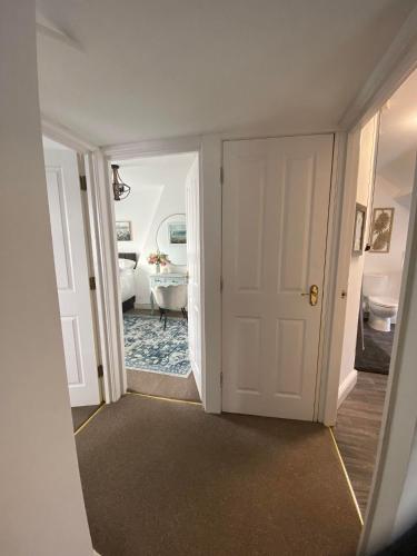 a hallway with a door leading to a bathroom at The Penthouse at Percy House Pet Friendly 2 Bedroom Apartment in Porthcawl Sleeps 4 people Located in the town centre in Porthcawl