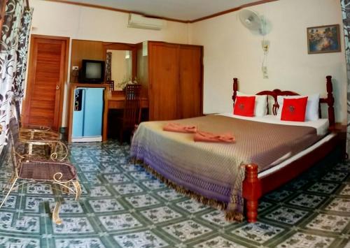 a bedroom with a large bed with red pillows at Anawin Bungalows in Ao Nang Beach
