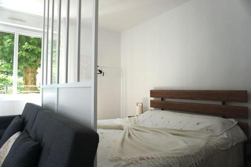 une chambre avec un lit et un canapé dans l'établissement Joli appartement 2 chambres au coeur du parc du Haut Jura, à Morez