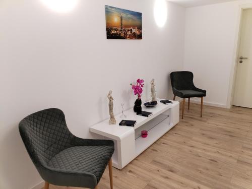 a living room with two chairs and a white table at Hotel Radevormwald in Radevormwald