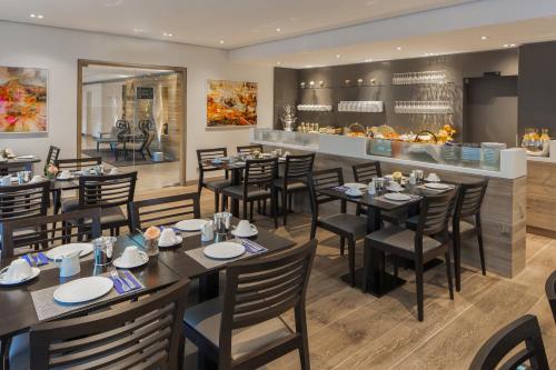 a restaurant with tables and chairs and a counter at The Alex Hotel in Freiburg im Breisgau