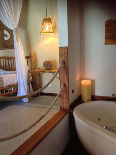 a bathroom with a hammock and a tub and a bed at Pousada Residencia Duna Paraiso in Maceió