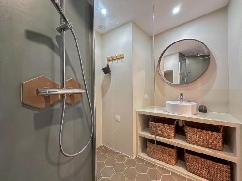 a bathroom with a shower and a sink and a mirror at L'Atelier des Vignes in Saint-Pantaléon