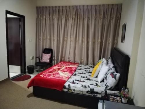 a bedroom with a bed and a chair at My Home Stay Apartment in Abu Dhabi