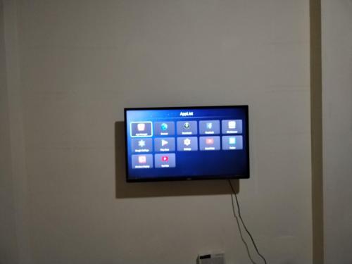 TV de pantalla plana colgada en la pared en My Home Stay Apartment, en Abu Dabi