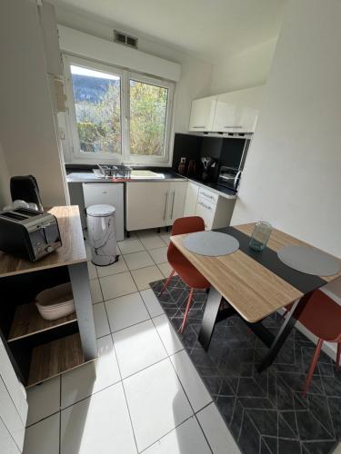 a kitchen with a table and two chairs and a table at Beau studio plein centre ville in Beauvais