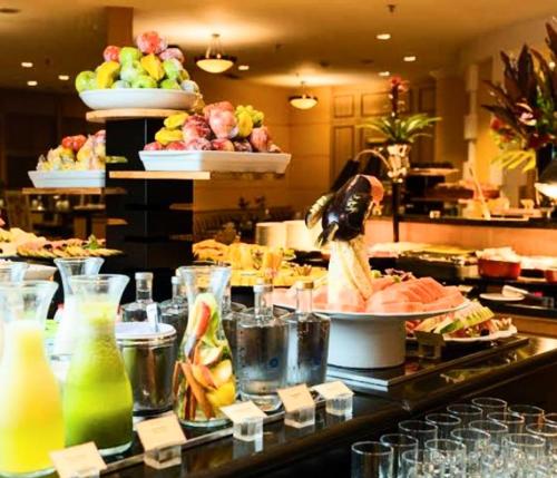 a buffet line with a bunch of food and drinks at Hotel M-RCURE Times Square MOEMA - Diamond Deluxe Duplex - Business Edition - Executive Class - By LuXXoR in Sao Paulo