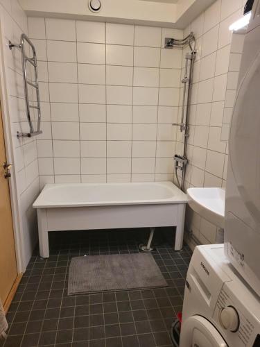 a bathroom with a tub and a toilet and a sink at Jude apartment in Sundbyberg