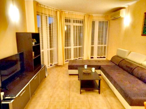 a living room with a couch and a table at Central Plaza Apartment in Sunny Beach