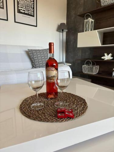 Una botella de vino y dos copas en una mesa. en DT Garden's Apartment, en Drama