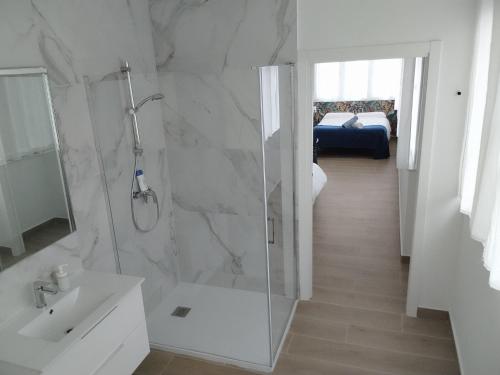 baño blanco con ducha y lavamanos en Apartamentos y Habitaciones KAI MARBELLA, en Marbella