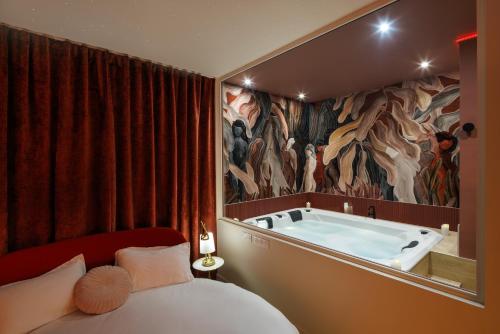 Schlafzimmer mit einem Bett und einer Badewanne in der Unterkunft Mountain Love in Saint-Claude