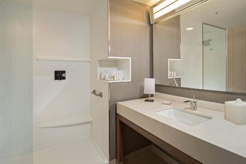a bathroom with a sink and a mirror and a shower at Courtyard by Marriott Concord in Concord