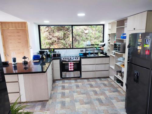 a kitchen with a stove and a large window at Paradise in Envigado- in Envigado