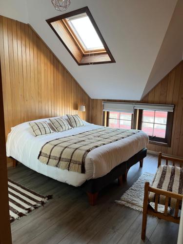 een slaapkamer met een groot bed en een dakraam bij ARCA HOTEL BOUTIQUE in Achao