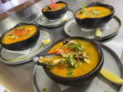 a group of bowls of food on plates on a table at ARCA HOTEL BOUTIQUE in Achao
