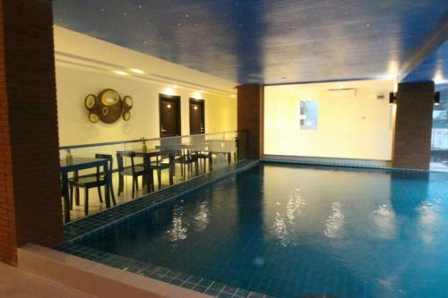 - une piscine avec une table et une salle à manger dans l'établissement Leelawadee Modern Resort Huaykwang, à Bangkok