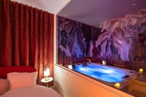 a room with a tub with a painting on the wall at Mountain Love in Saint-Claude