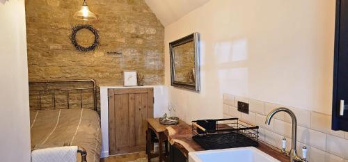 a bathroom with a sink and a bed and a tub at The Little Mews in Blockley