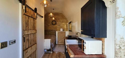 a kitchen with a sink and a microwave on a counter at The Little Mews in Blockley