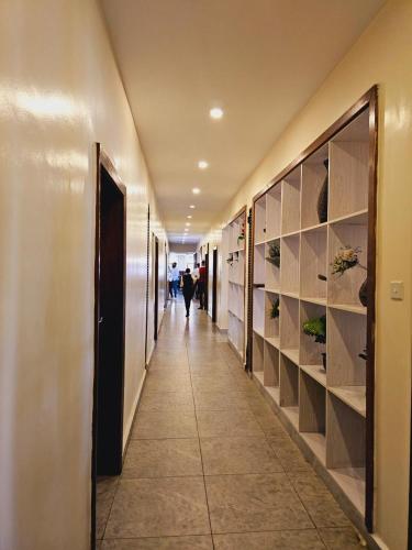 a hallway of a building with a person walking down it at Nomad Paradise Hotel in Nairobi