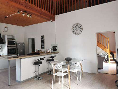 cocina con paredes blancas, mesa y sillas en Chez Alex et Sophie, en Louzac - Saint-André