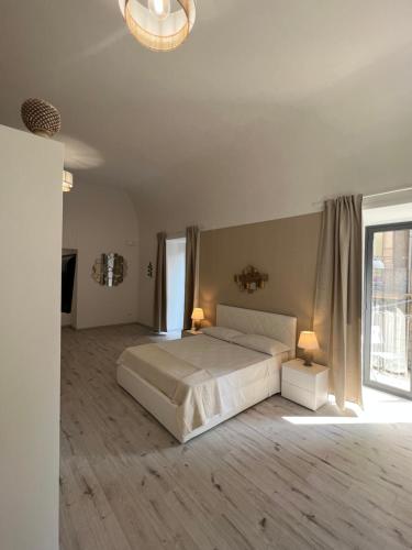 a bedroom with a bed and a large window at San Giuliano Palace in Catania