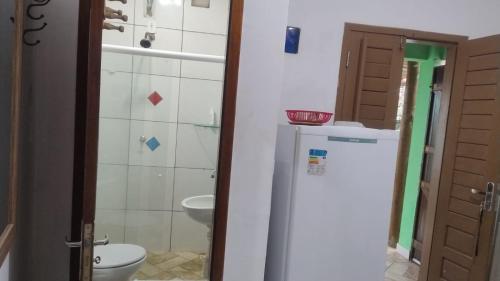 a bathroom with a toilet and a sink and a refrigerator at Pousada PETIT CHALET Canoa Quebrada in Canoa Quebrada