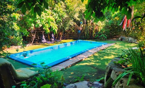 a swimming pool in the middle of a yard at El Jardin, Eco Cabañas Boutique in San Alfonso