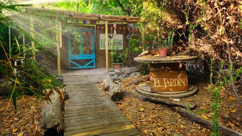 a wooden pathway leading to a door with a sign on it at El Jardin, Eco Cabañas Boutique in San Alfonso