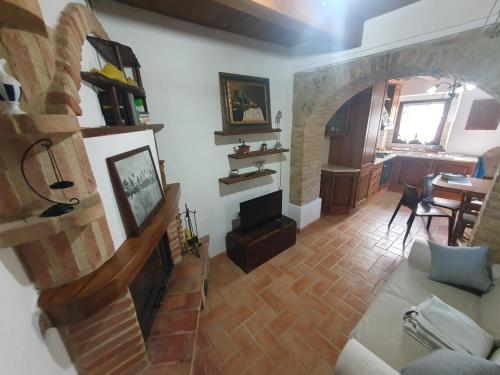 a living room with a fireplace and a dining room at La Casetta di Gino e Marcella in Sassoferrato