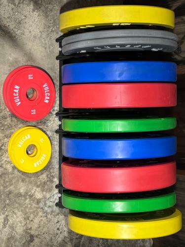 a stack of colorful plastic plates next to two disks at Buttons By The Beach - beach house on King Island in Yambacoona