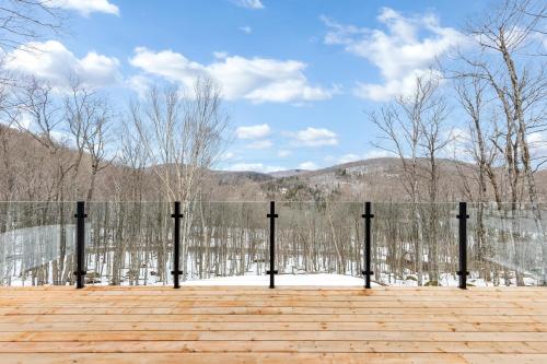 a fence with trees and mountains in the background at Le Chamonix/Mountain view/Golf course/Activities! in Saint-Faustin