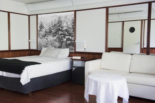 ein Schlafzimmer mit einem Bett und einem Sofa in der Unterkunft Hotel Royal Ruka in Ruka