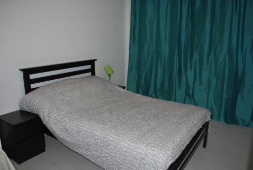 a bed in a bedroom with a green curtain at 227 Santorini Azure Urban Resort Condo Unit in Manila