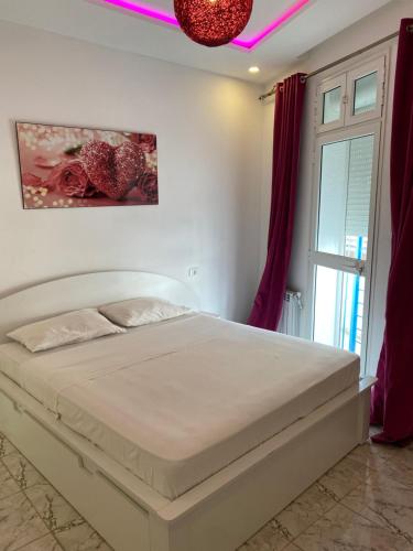 a bedroom with a white bed and a window at Appartement coeur de ville Tunis in Tunis