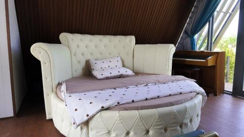 a white chair with a bed in a room at Lúa Homestay in Soc Trang