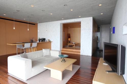 a living room with a white couch and a television at Hotel Setre Kobe Maiko in Kobe