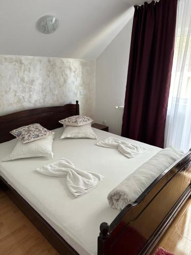 Casa Natalia Raisa Arieșeni في أرياسيني: غرفة نوم بسرير ذو شراشف ووسائد بيضاء