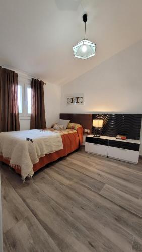 ein großes Schlafzimmer mit einem großen Bett und Holzböden in der Unterkunft Casa María Martillo in Canillas de Aceituno
